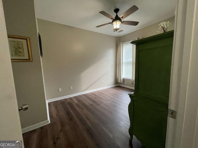 empty room with ceiling fan and dark hardwood / wood-style flooring