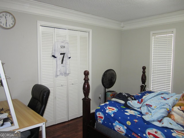 bedroom featuring a textured ceiling, a closet, and crown molding