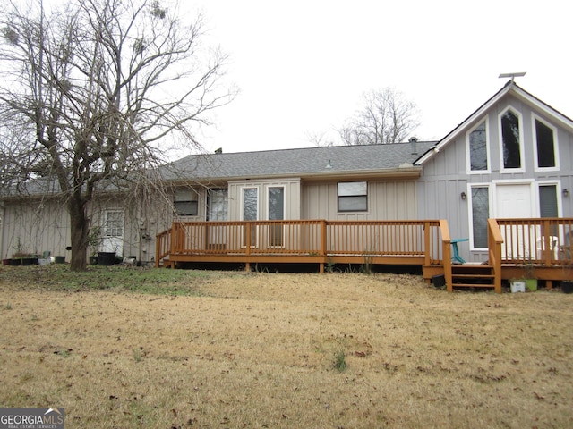 rear view of house with a yard and a wooden deck