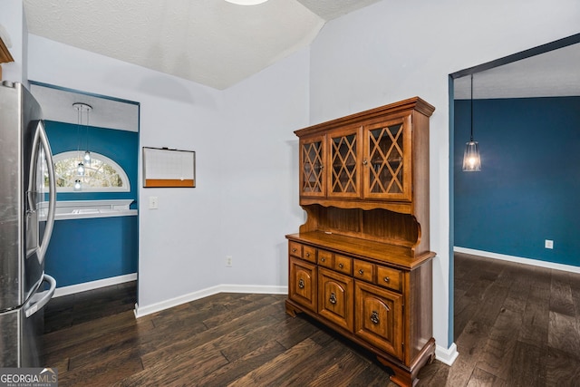 interior space with a textured ceiling, dark hardwood / wood-style flooring, vaulted ceiling, and a notable chandelier