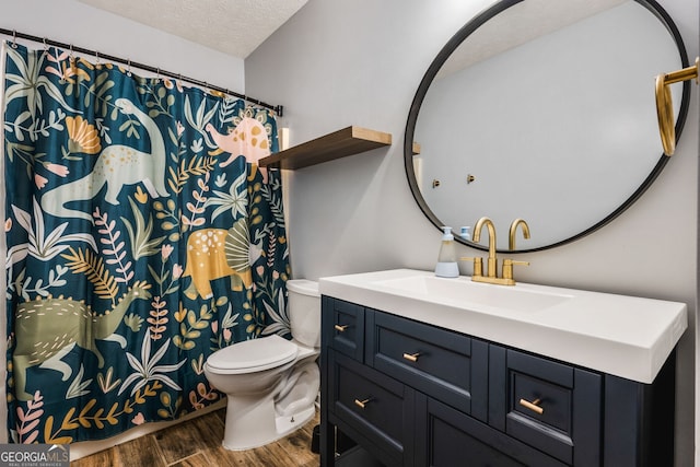 bathroom with vanity, toilet, wood-type flooring, and a textured ceiling