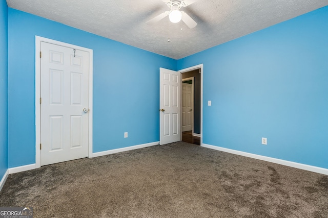 unfurnished bedroom featuring carpet, a textured ceiling, and ceiling fan