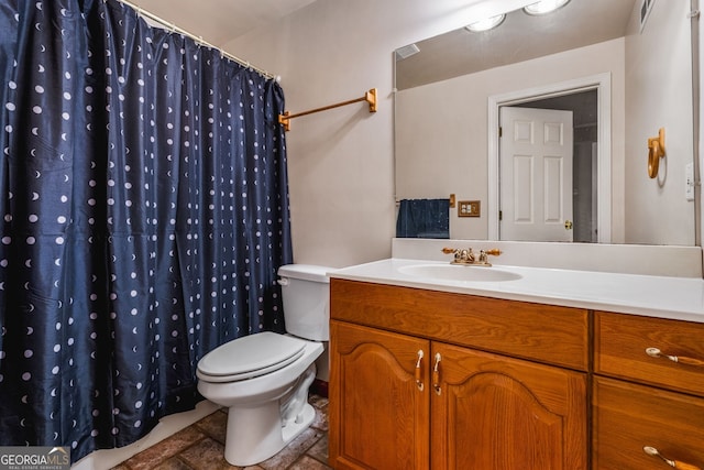 bathroom featuring curtained shower, vanity, and toilet