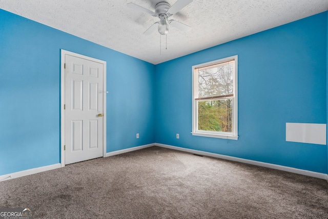 spare room featuring carpet, ceiling fan, and a textured ceiling