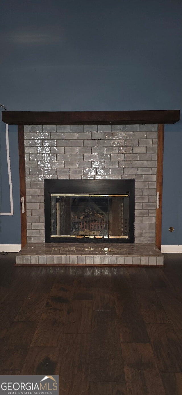 room details featuring wood-type flooring and a brick fireplace