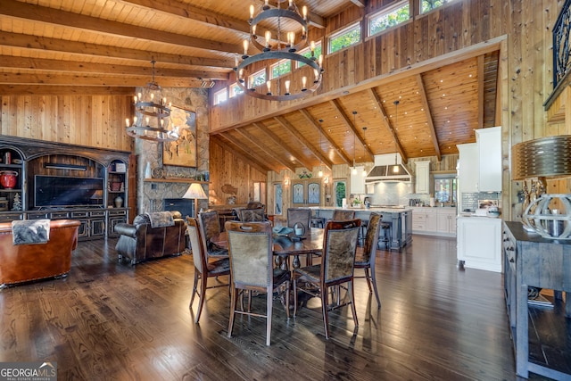 dining room featuring beamed ceiling, a fireplace, a healthy amount of sunlight, and wood ceiling