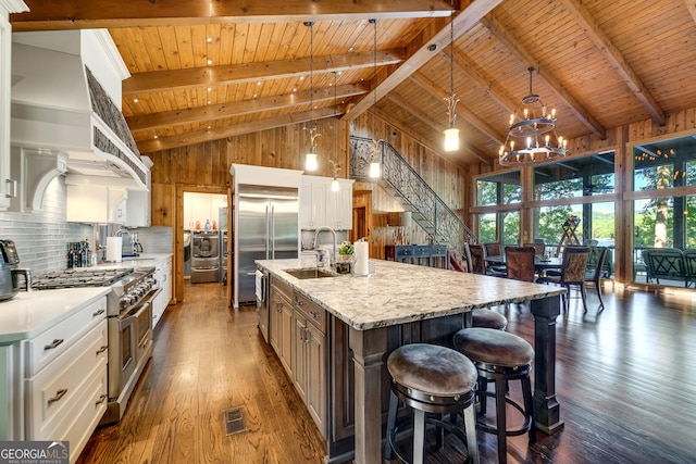 kitchen featuring sink, a center island with sink, high vaulted ceiling, white cabinetry, and hanging light fixtures