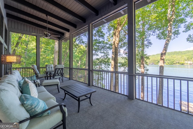 unfurnished sunroom with a wealth of natural light, ceiling fan, beamed ceiling, and a water view