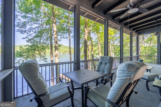 sunroom with lofted ceiling with beams, a water view, ceiling fan, and wooden ceiling