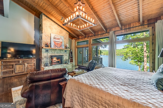 bedroom with high vaulted ceiling, a stone fireplace, a water view, hardwood / wood-style flooring, and beam ceiling