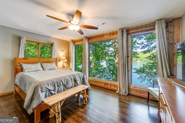 bedroom with multiple windows, access to outside, ceiling fan, and dark wood-type flooring