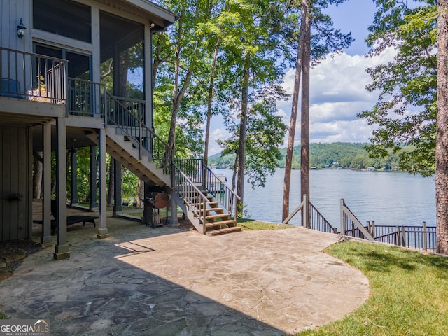 view of patio featuring a sunroom and a water view