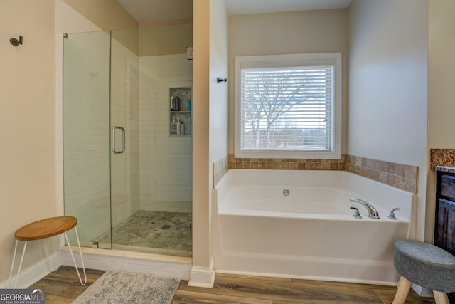 bathroom with independent shower and bath and hardwood / wood-style flooring