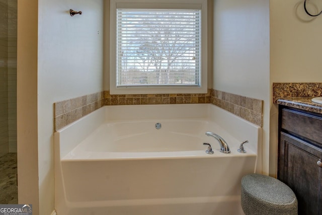 bathroom featuring vanity and a bath