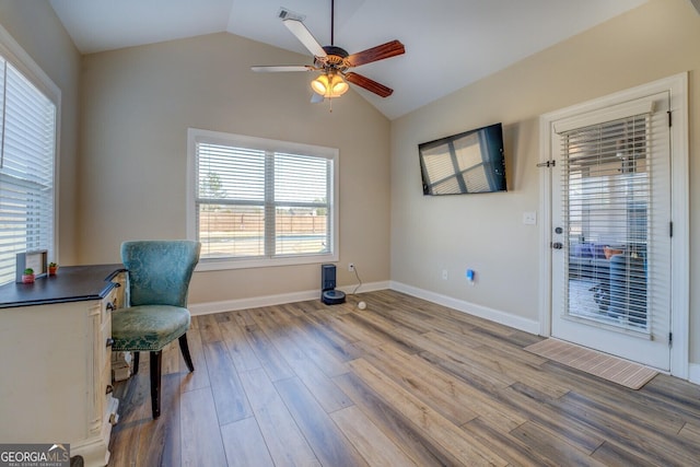 home office featuring ceiling fan, wood-type flooring, and vaulted ceiling