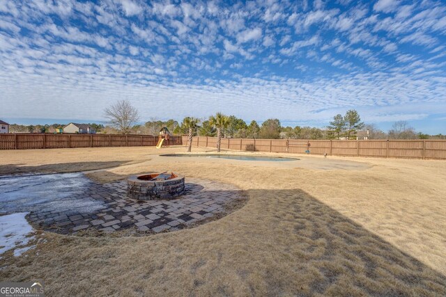 view of yard featuring an outdoor fire pit and a playground