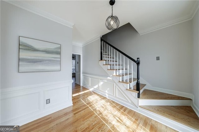 staircase featuring crown molding and hardwood / wood-style flooring