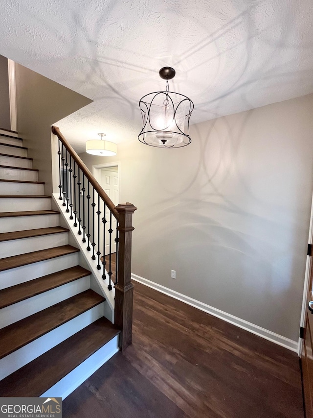 staircase featuring hardwood / wood-style floors and a textured ceiling