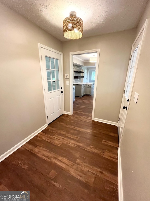 doorway featuring dark hardwood / wood-style flooring and a textured ceiling