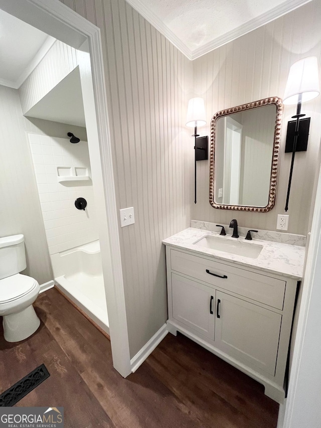 bathroom with hardwood / wood-style floors, vanity, a shower, toilet, and ornamental molding