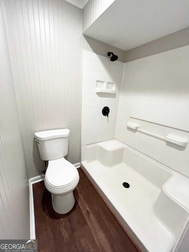 bathroom with hardwood / wood-style flooring, toilet, and walk in shower