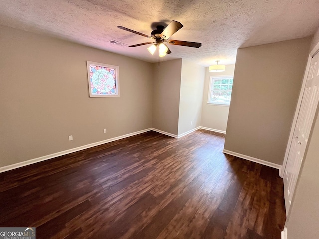 unfurnished room featuring a textured ceiling, dark hardwood / wood-style flooring, and ceiling fan