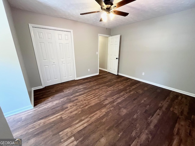 unfurnished bedroom with a textured ceiling, dark hardwood / wood-style floors, and ceiling fan