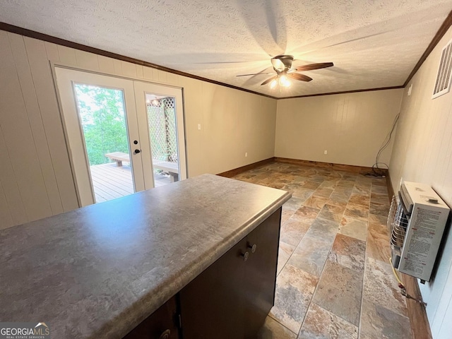 interior space with heating unit, ceiling fan, french doors, and crown molding