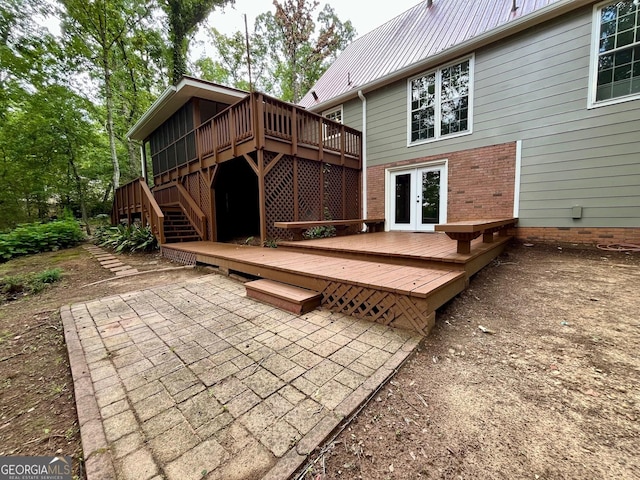 back of property featuring a wooden deck, a patio area, and french doors