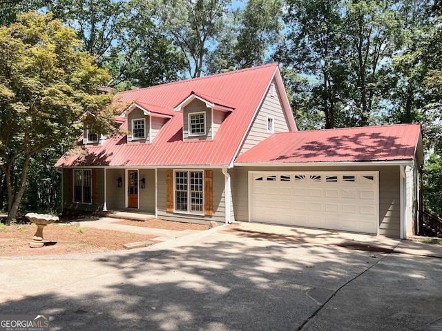 cape cod home with covered porch and a garage