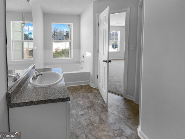 bathroom with vanity and a bath