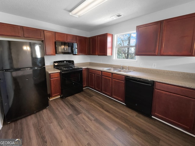 kitchen featuring dark hardwood / wood-style flooring, sink, a textured ceiling, and black appliances