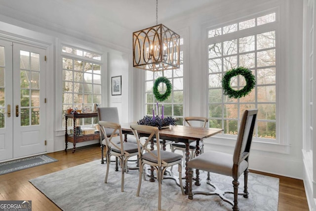 dining room featuring a chandelier, wood-type flooring, and french doors