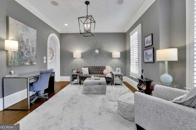 living room with crown molding, dark wood-type flooring, and an inviting chandelier