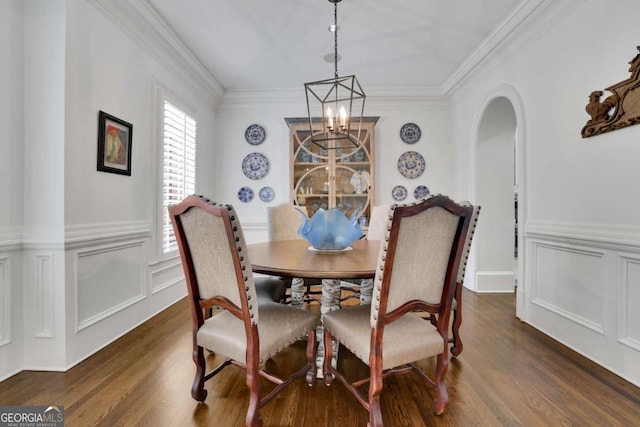 dining space with crown molding, dark wood-type flooring, and a notable chandelier