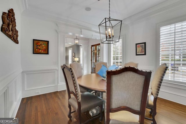 dining room with a chandelier, dark hardwood / wood-style flooring, a healthy amount of sunlight, and ornamental molding