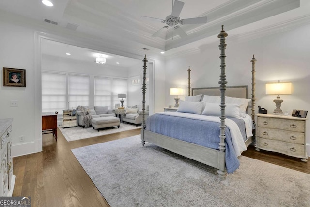 bedroom featuring ceiling fan, dark hardwood / wood-style floors, crown molding, and a tray ceiling