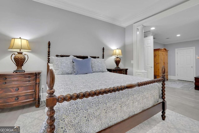 bedroom featuring light wood-type flooring, ornate columns, and crown molding