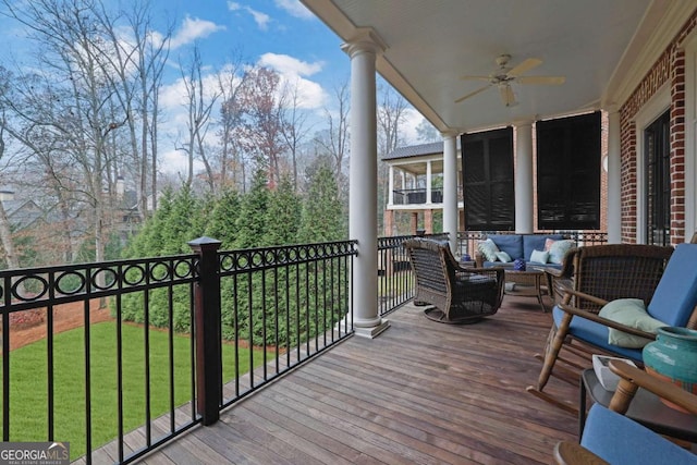 wooden terrace featuring outdoor lounge area, a yard, and ceiling fan