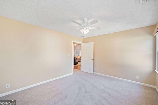 carpeted spare room featuring ceiling fan and a textured ceiling