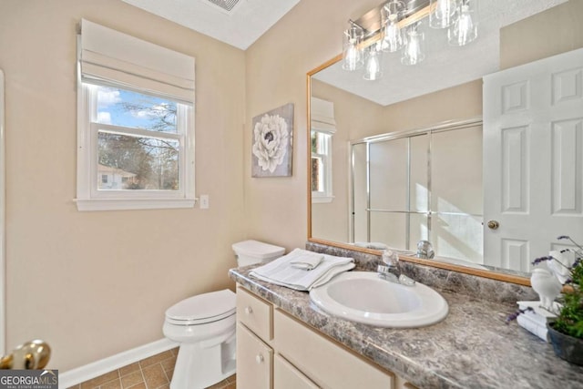 bathroom featuring tile patterned flooring, vanity, an enclosed shower, and toilet