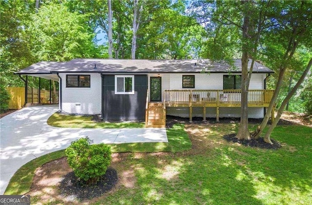 rear view of house featuring a yard, a deck, and a carport