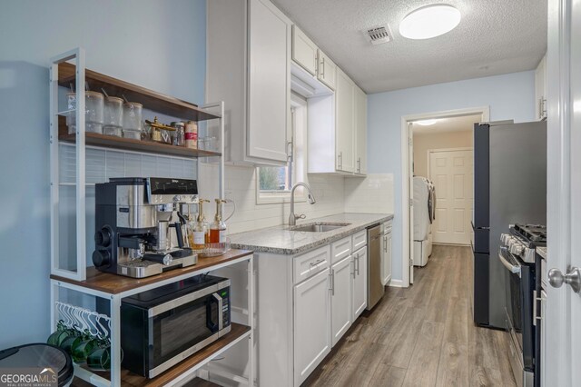 kitchen featuring white cabinets, a textured ceiling, sink, and stainless steel appliances