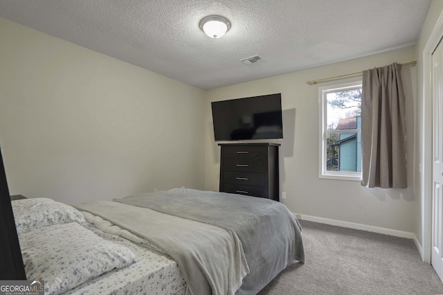 carpeted bedroom featuring a textured ceiling