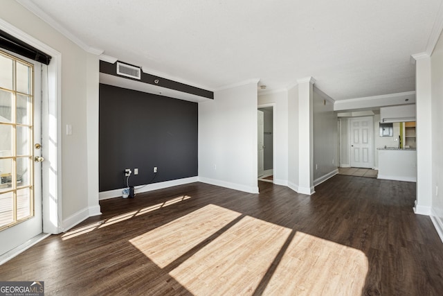 empty room featuring dark wood-type flooring and ornamental molding