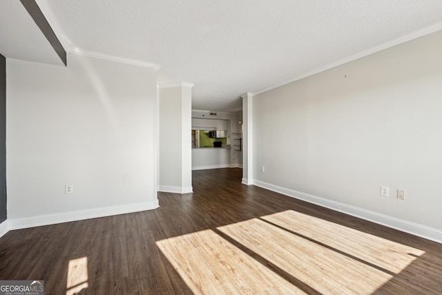 empty room with a textured ceiling, dark hardwood / wood-style floors, and ornamental molding