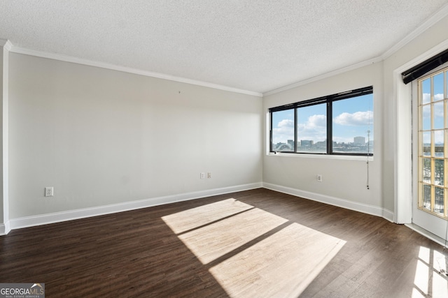 empty room with dark hardwood / wood-style flooring, a textured ceiling, and ornamental molding