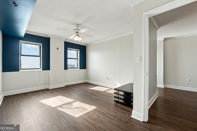 empty room with a textured ceiling, dark hardwood / wood-style floors, ceiling fan, and crown molding