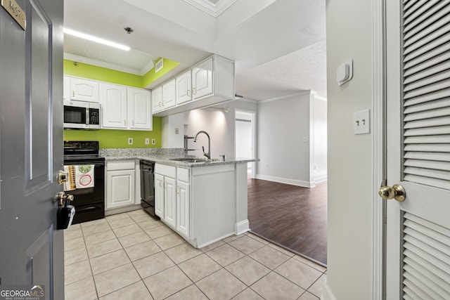 kitchen with sink, white cabinets, kitchen peninsula, light tile patterned flooring, and black appliances