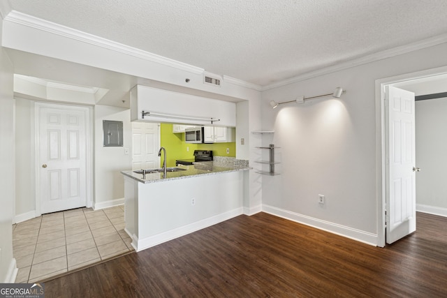 kitchen with kitchen peninsula, light stone countertops, sink, white cabinets, and black electric range oven